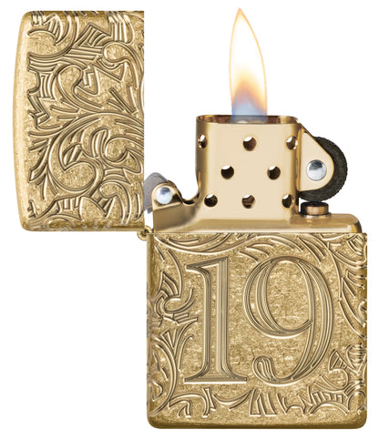 Zippo 1932 Filigree Design  Armor® Tumbled Brass Windproof Lighter with its lid open and lit.